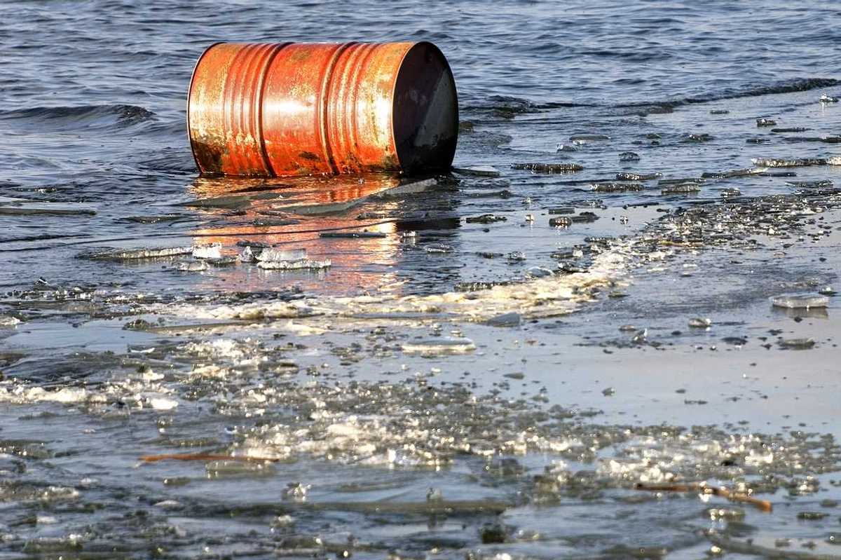 A rusty oil barrel floating in icy water