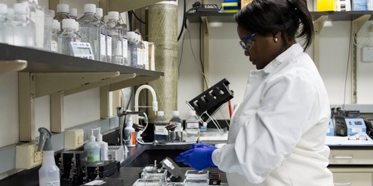 A scientist working on samples at a lab counter