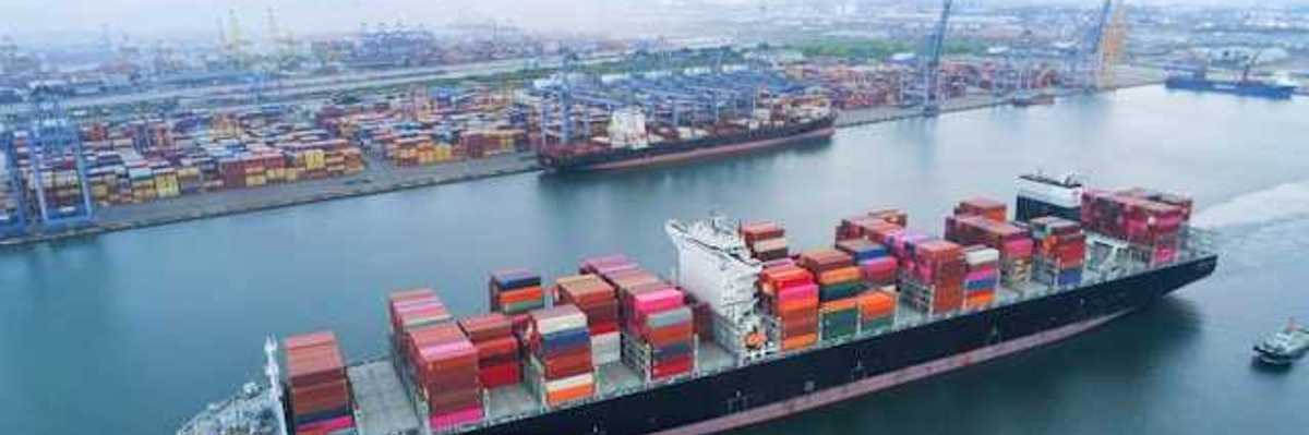 A shipping dock with a loaded tanker floating by