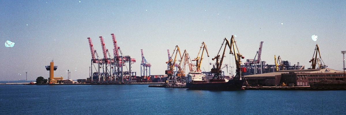 A shipping port with ships, docks and cranes on a sunny day