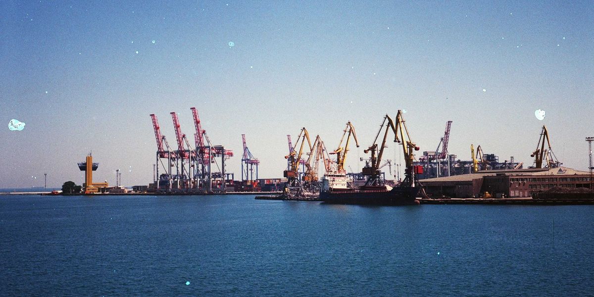 A shipping port with ships, docks and cranes on a sunny day