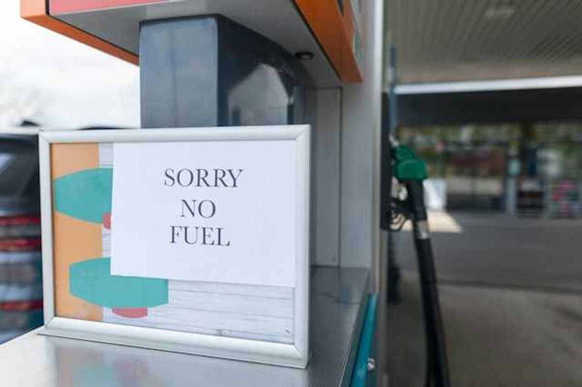 A sign that says 'sorry no fuel' next to a gas station pump