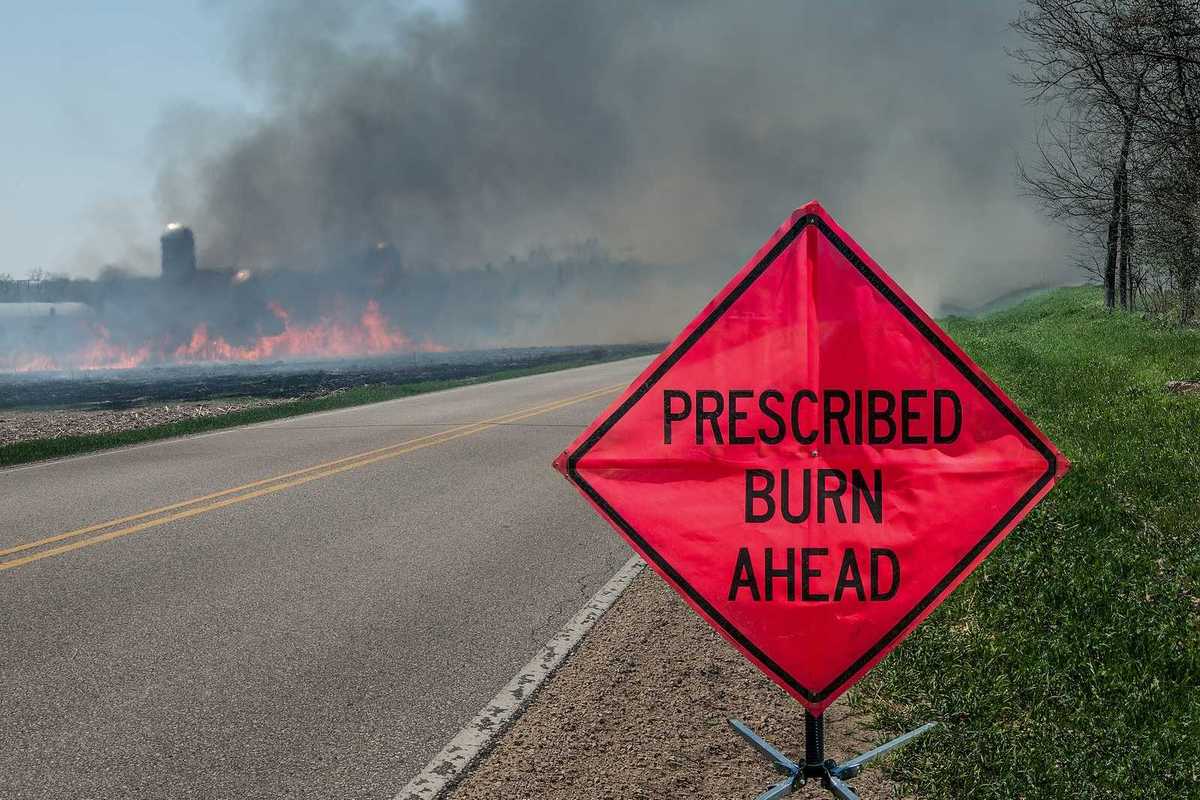A sign warns motorists of a controlled burn area ahead on a farm in southern Wisconsin