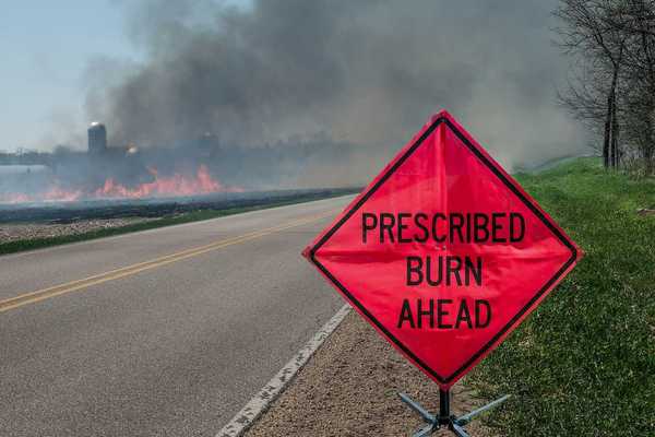A sign warns motorists of a controlled burn area ahead on a farm in southern Wisconsin