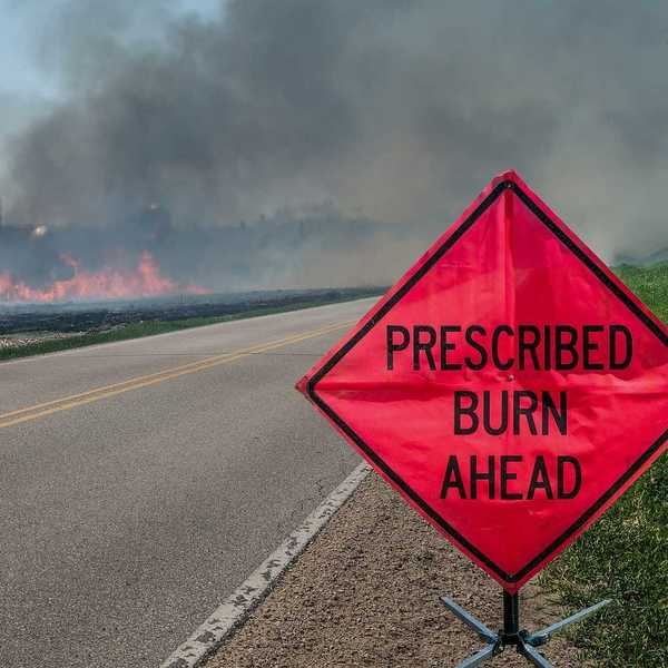 A sign warns motorists of a controlled burn area ahead on a farm in southern Wisconsin