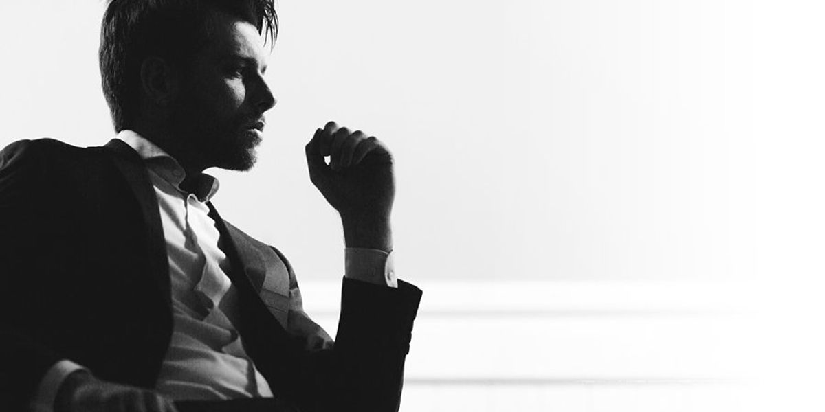 A silhouette of a businessman sitting in a chair.