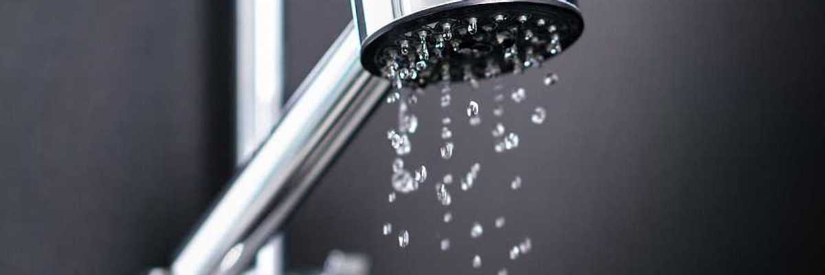 A silver shower head with water coming out of it