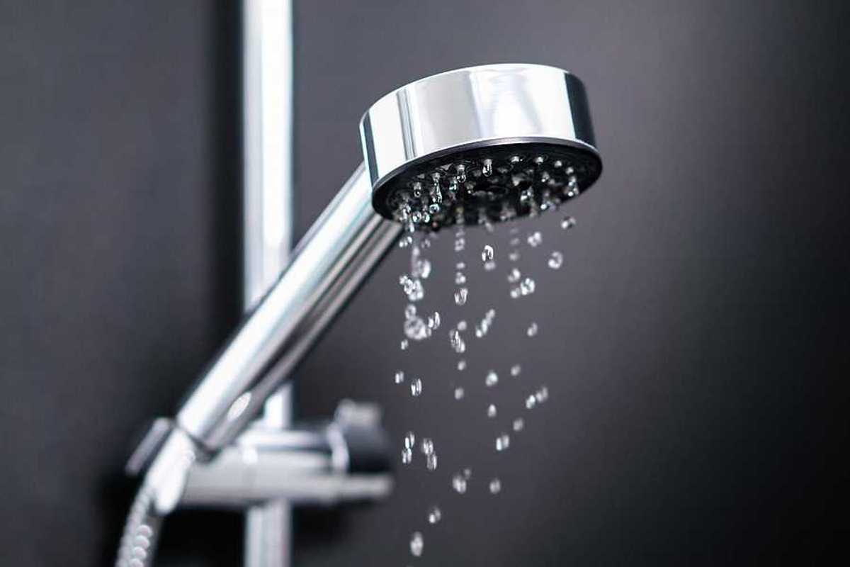 A silver shower head with water coming out of it