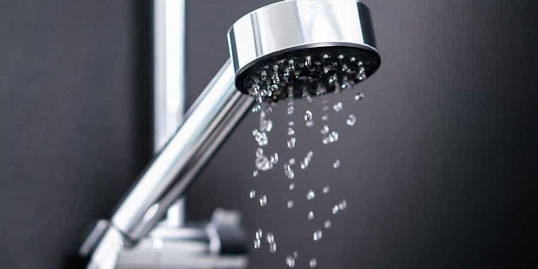 A silver shower head with water coming out of it