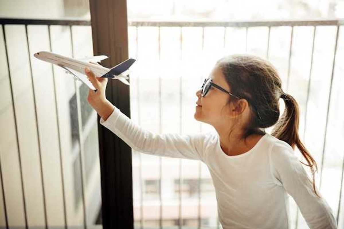 A small girl holding a model of an airplane