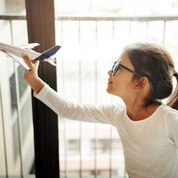 A small girl holding a model of an airplane