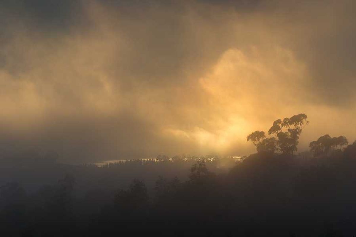 A smoky landscape with the sun in the background