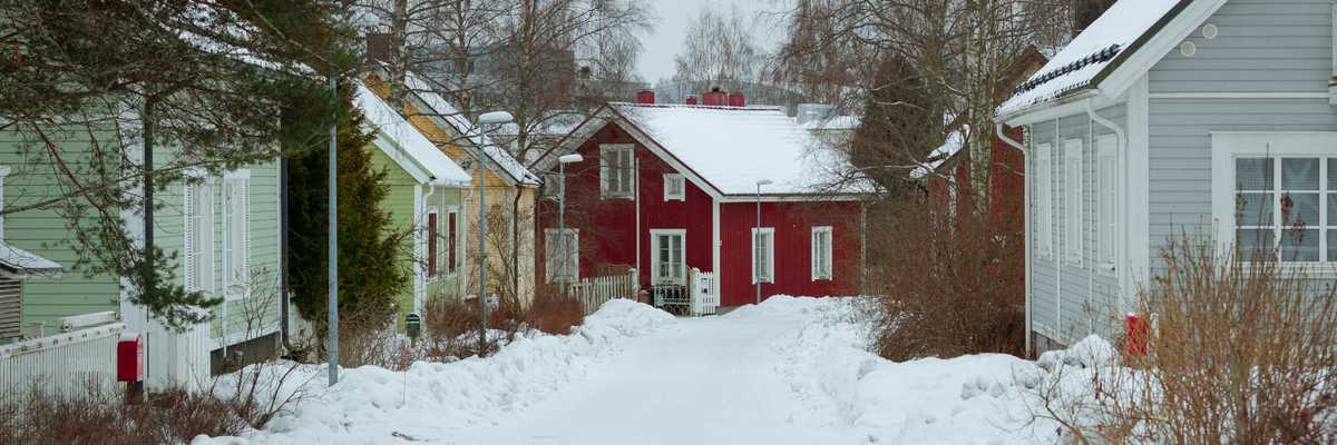 a snow covered street lined with small houses