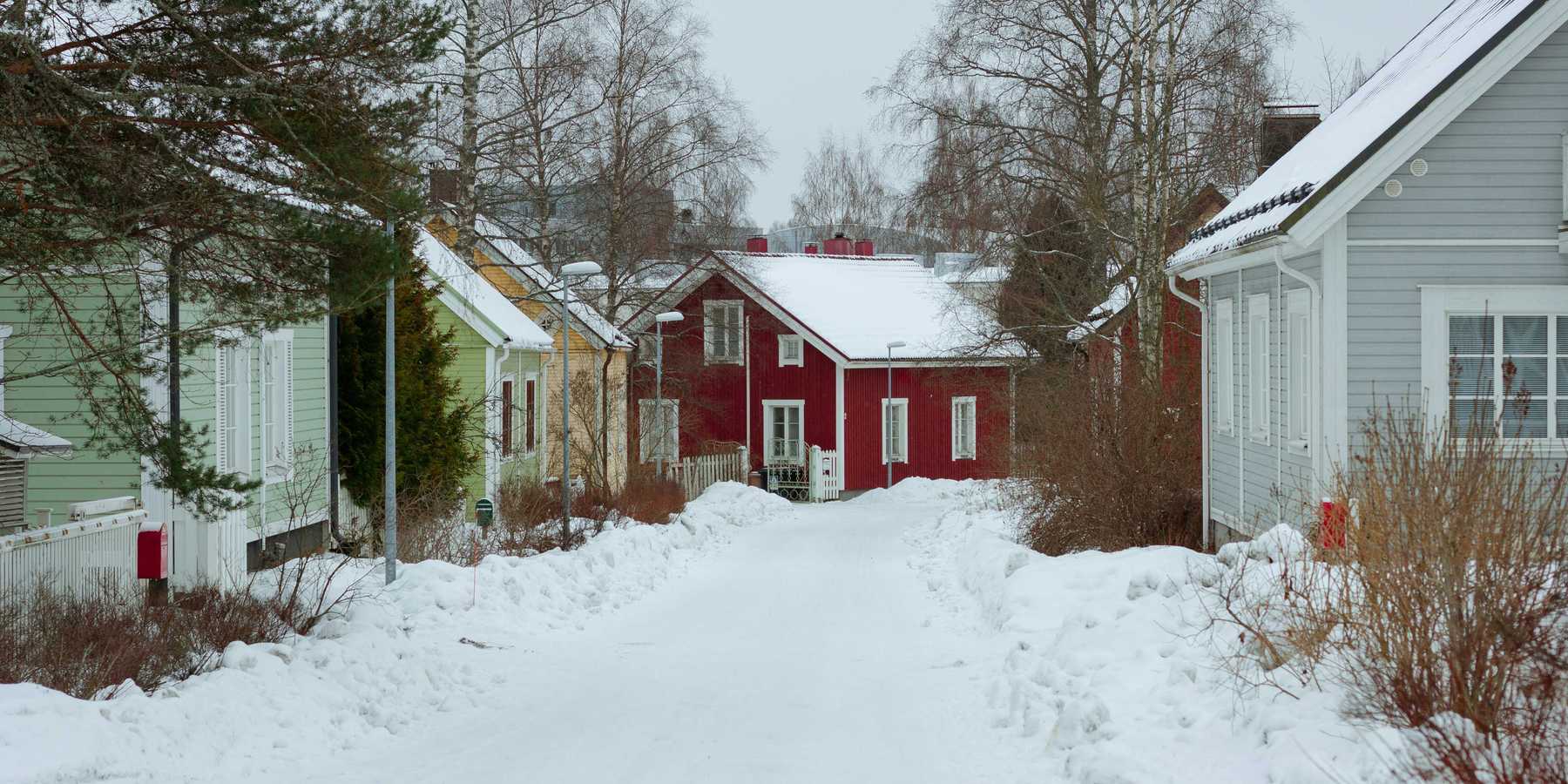 a snow covered street lined with small houses
