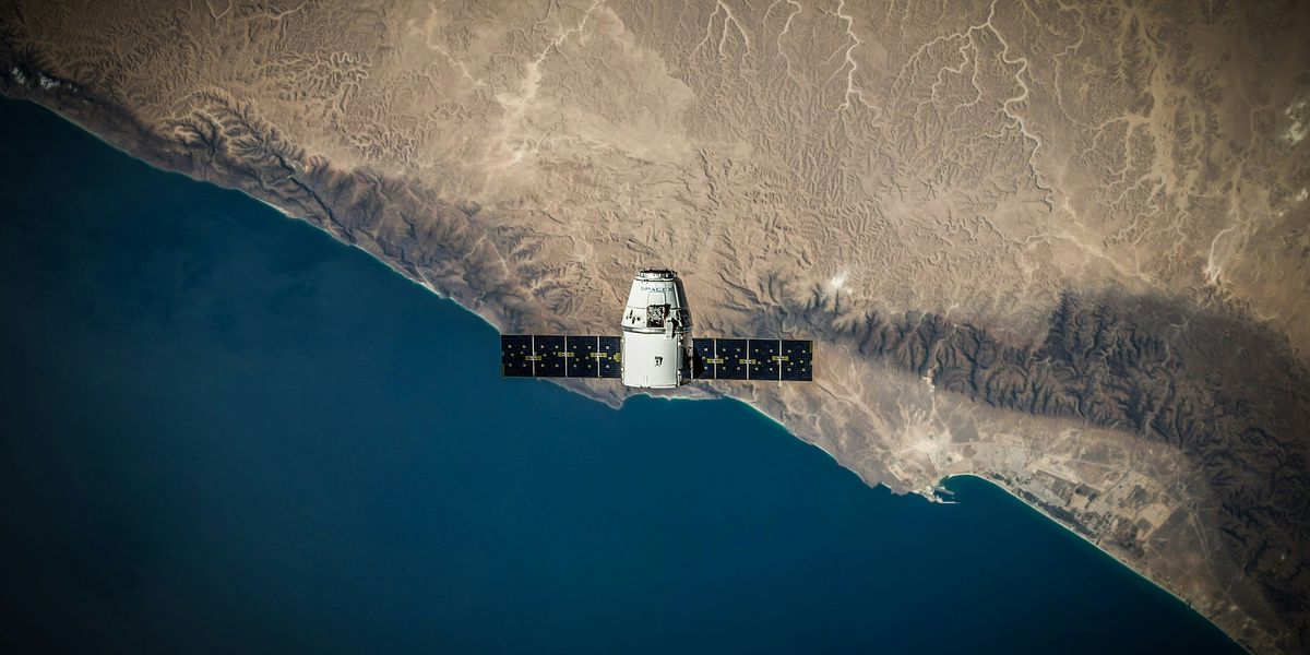 A space satellite hovering above the coastline.