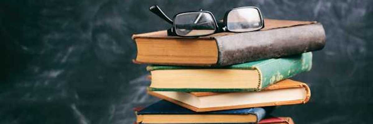A stack of books with a pair of readers sitting atop it