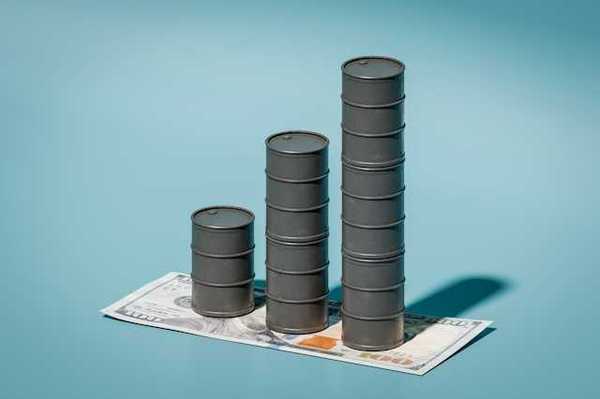 A stack of three oil barrels on top of a one hundred dollar bill against a blue background