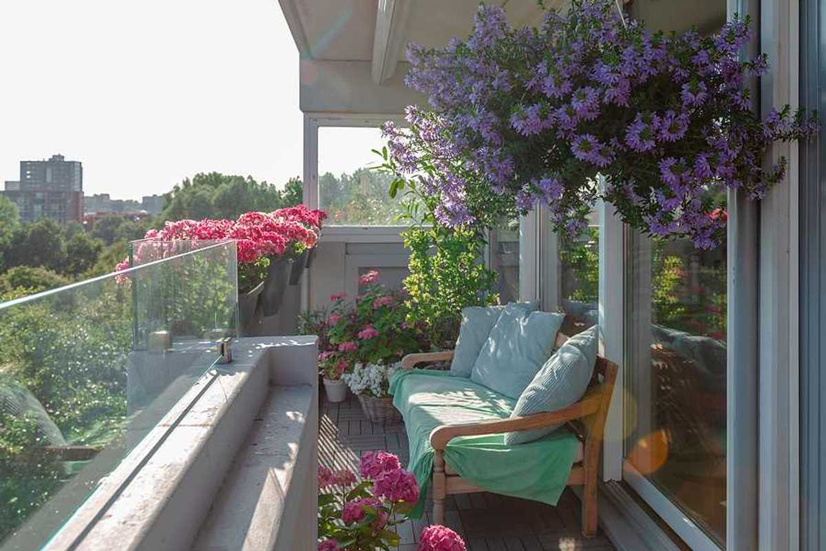 A sunny balcony with a bench and flower pots
