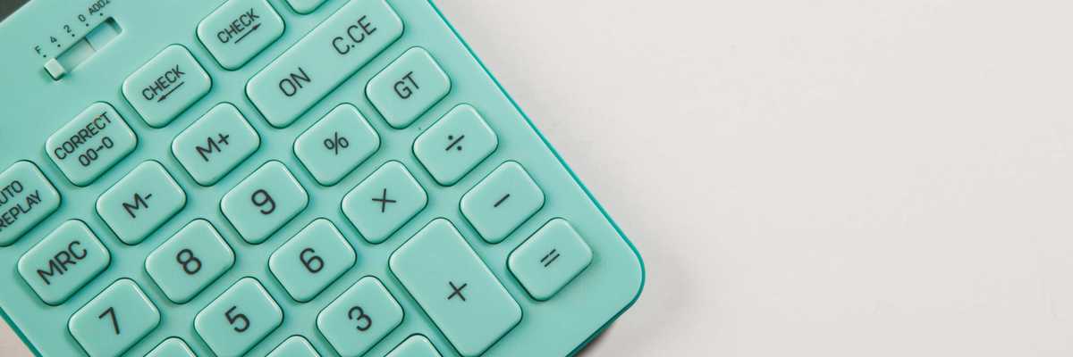 A teal calculator rests on a white surface.
