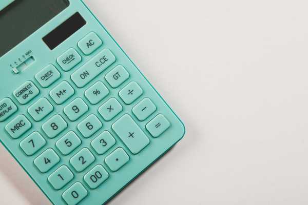 A teal calculator rests on a white surface.