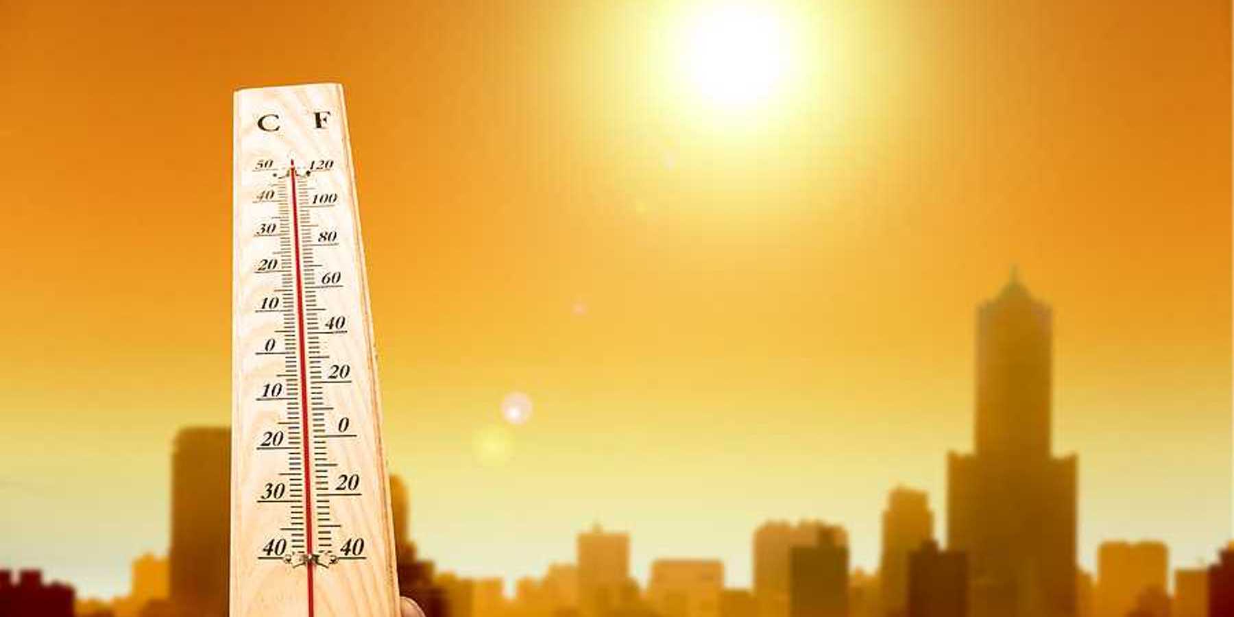 A thermometer showing hot temperatures with the outline of a city in the background