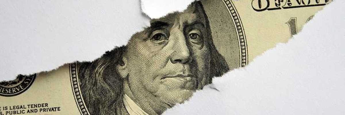 A torn white piece of paper with a $100 bill shown behind it