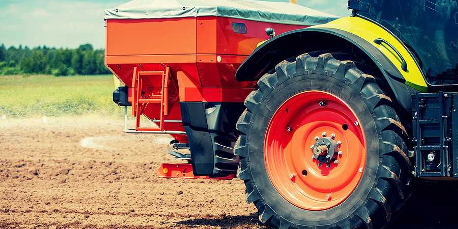 A tractor putting fertilizer on a farm field
