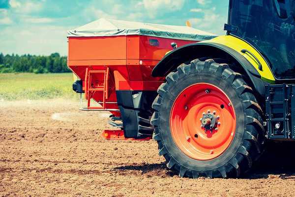 A tractor putting fertilizer on a farm field