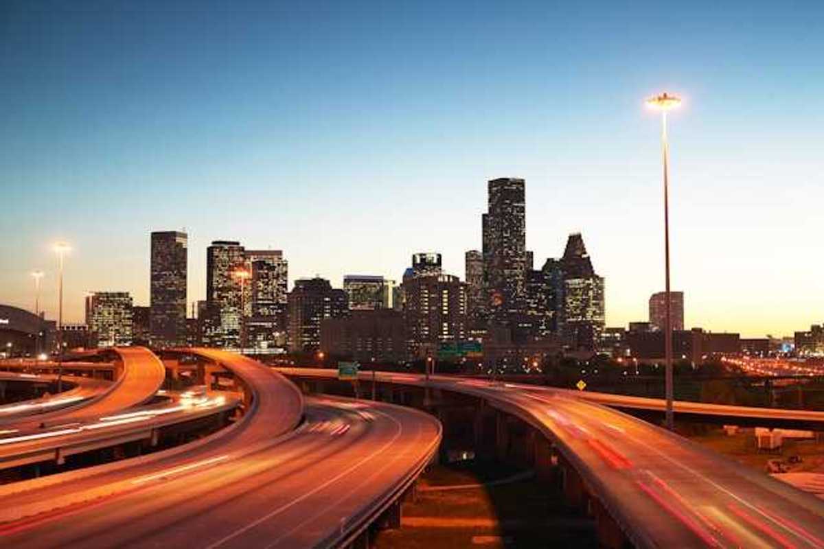 A view at dusk of highways leading into an urban downtown with skyscapers