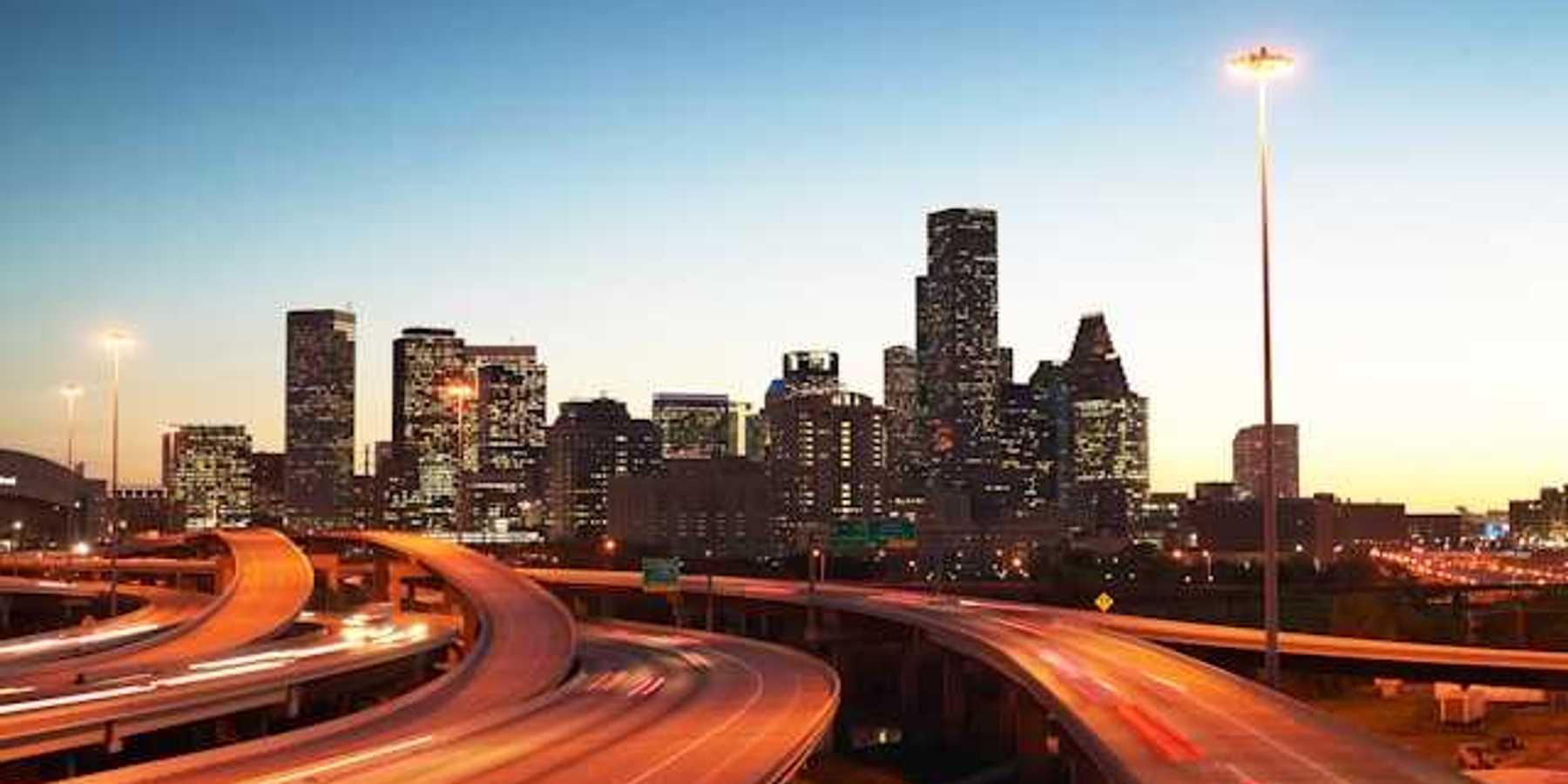 A view at dusk of highways leading into an urban downtown with skyscapers