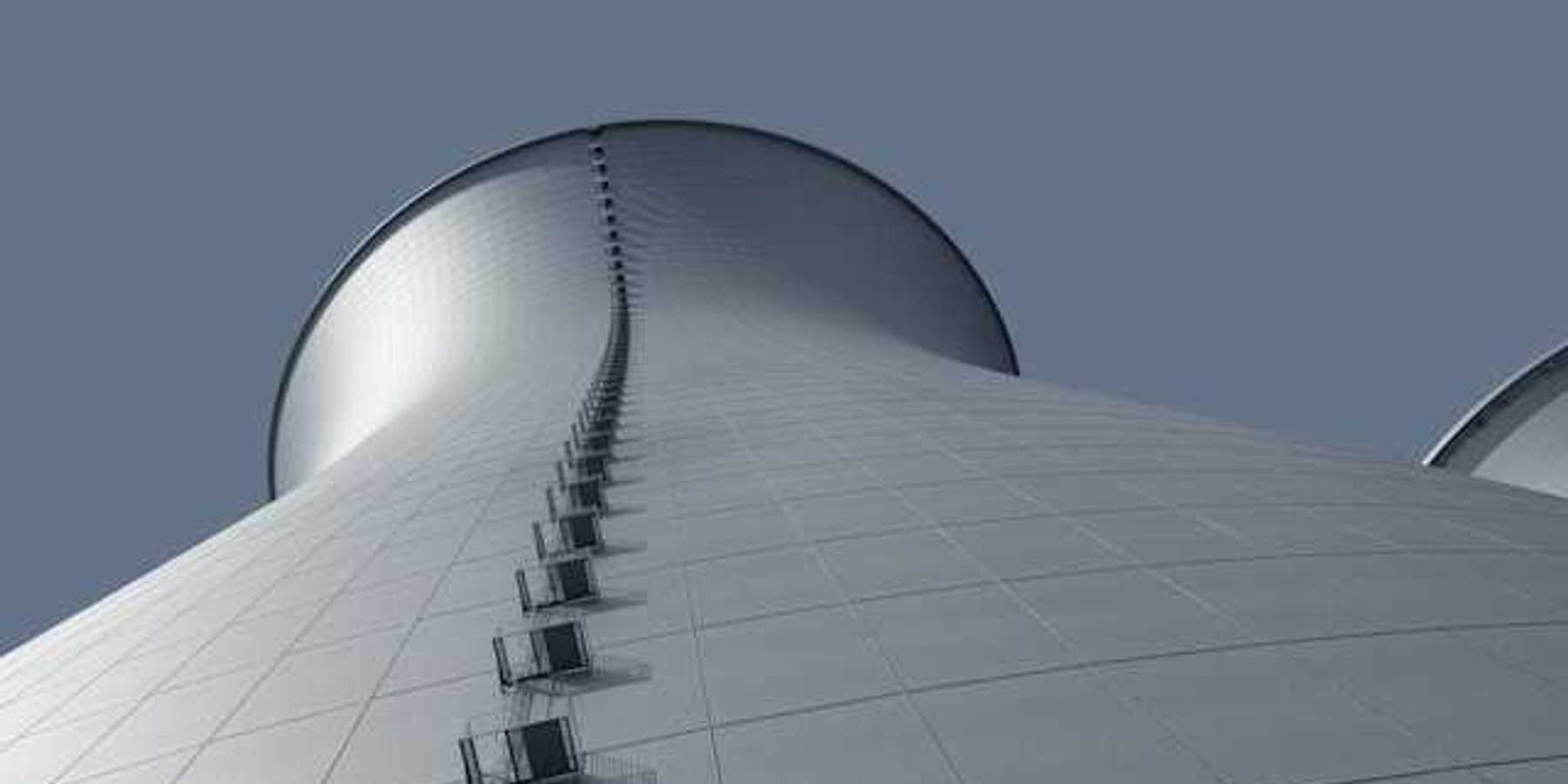 A view from below of a power cooling tower against a blue sky