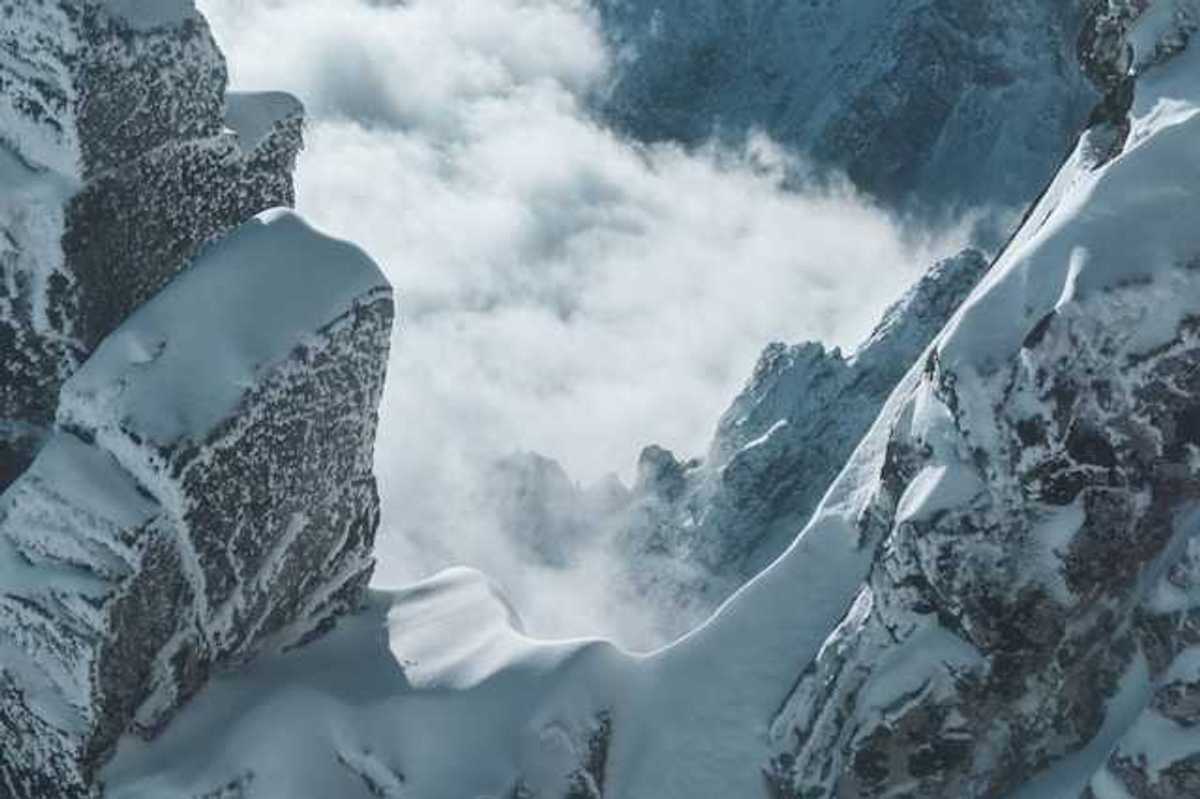 A view into the corridor of a snowy mountain with fog in the distance