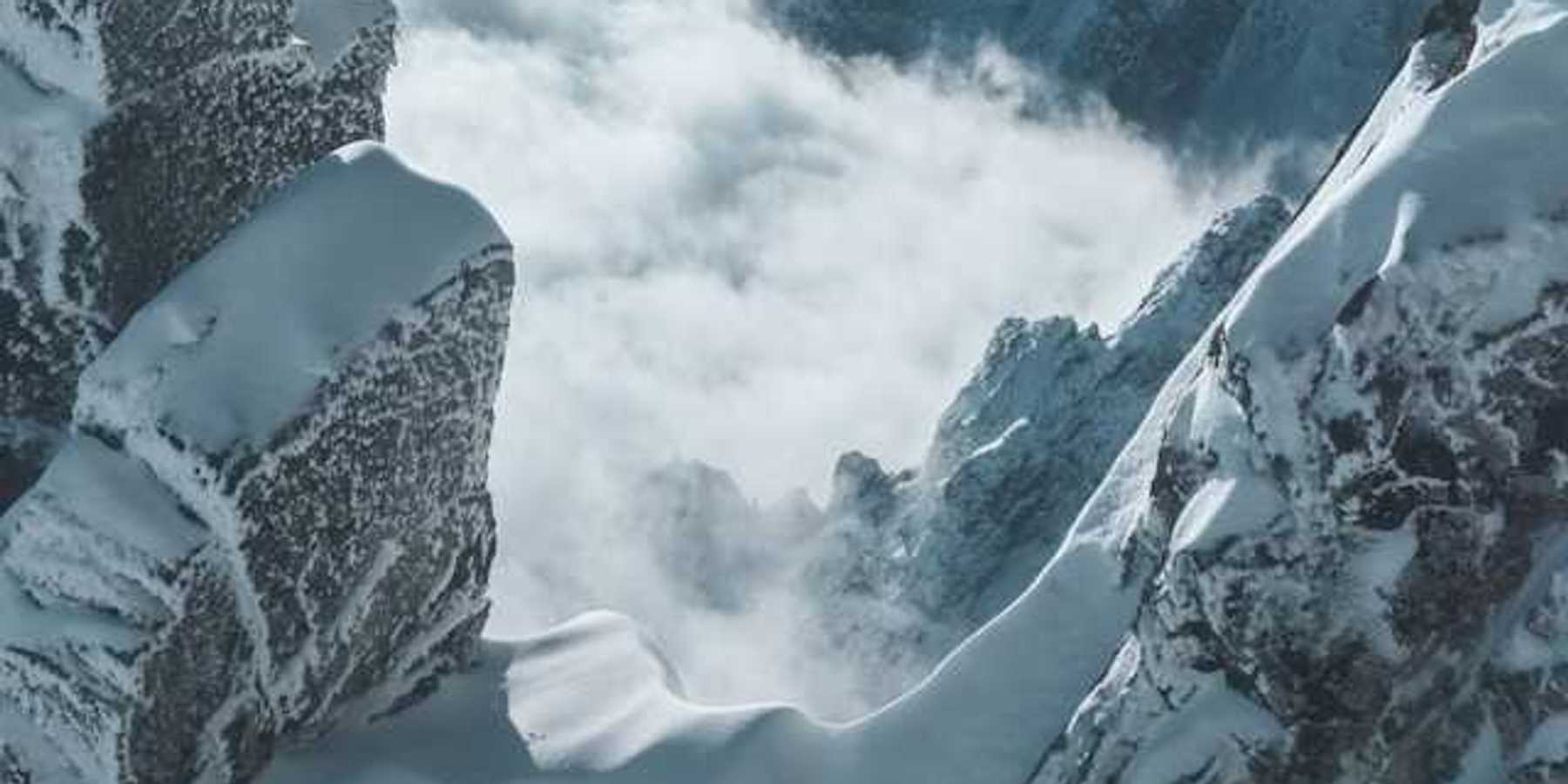 A view into the corridor of a snowy mountain with fog in the distance