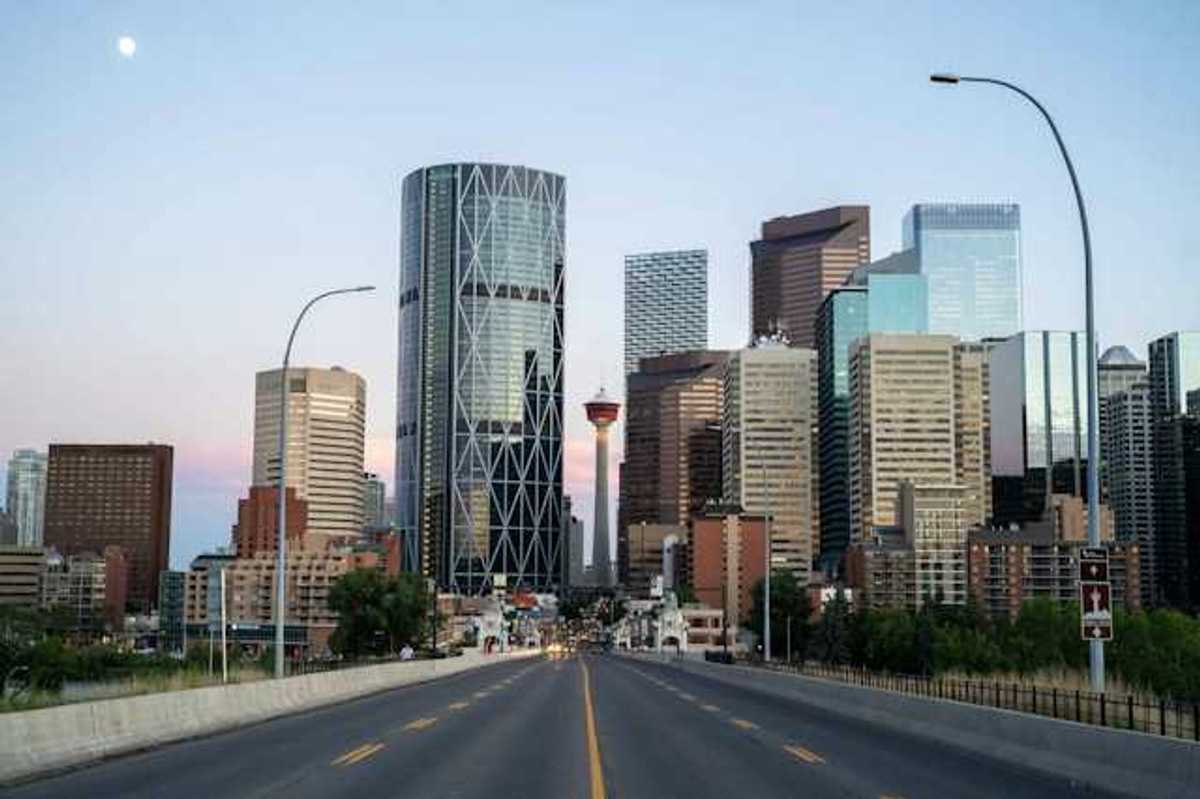 A view of a city skyline with a freeway heading toward it