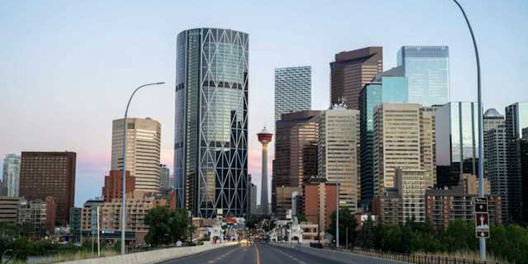 A view of a city skyline with a freeway heading toward it