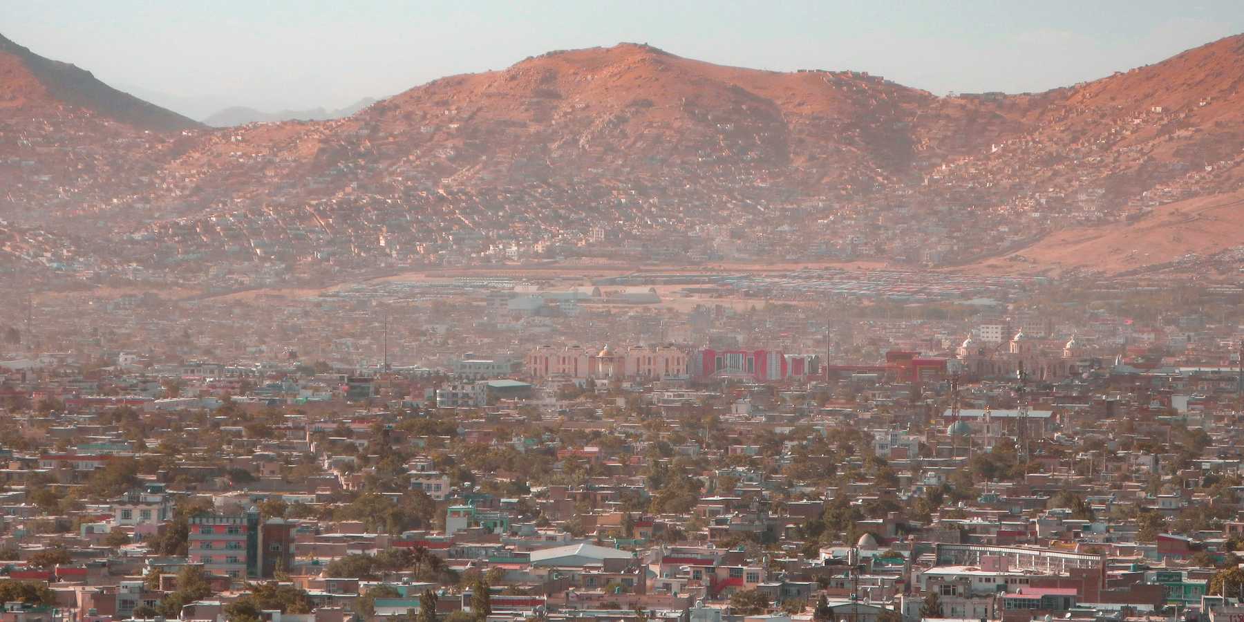 a view of a city with dry mountains in the background.