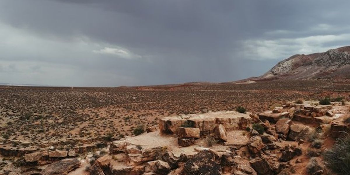 A view of a dry, desert landscape with clouds in the background.