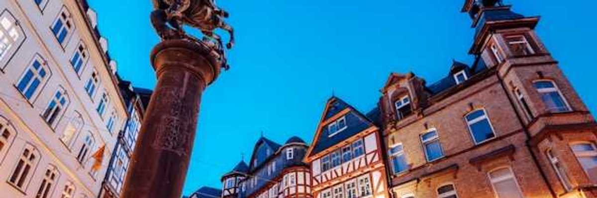 A view of a European square with half-timbered houses and a status of a man on a horse