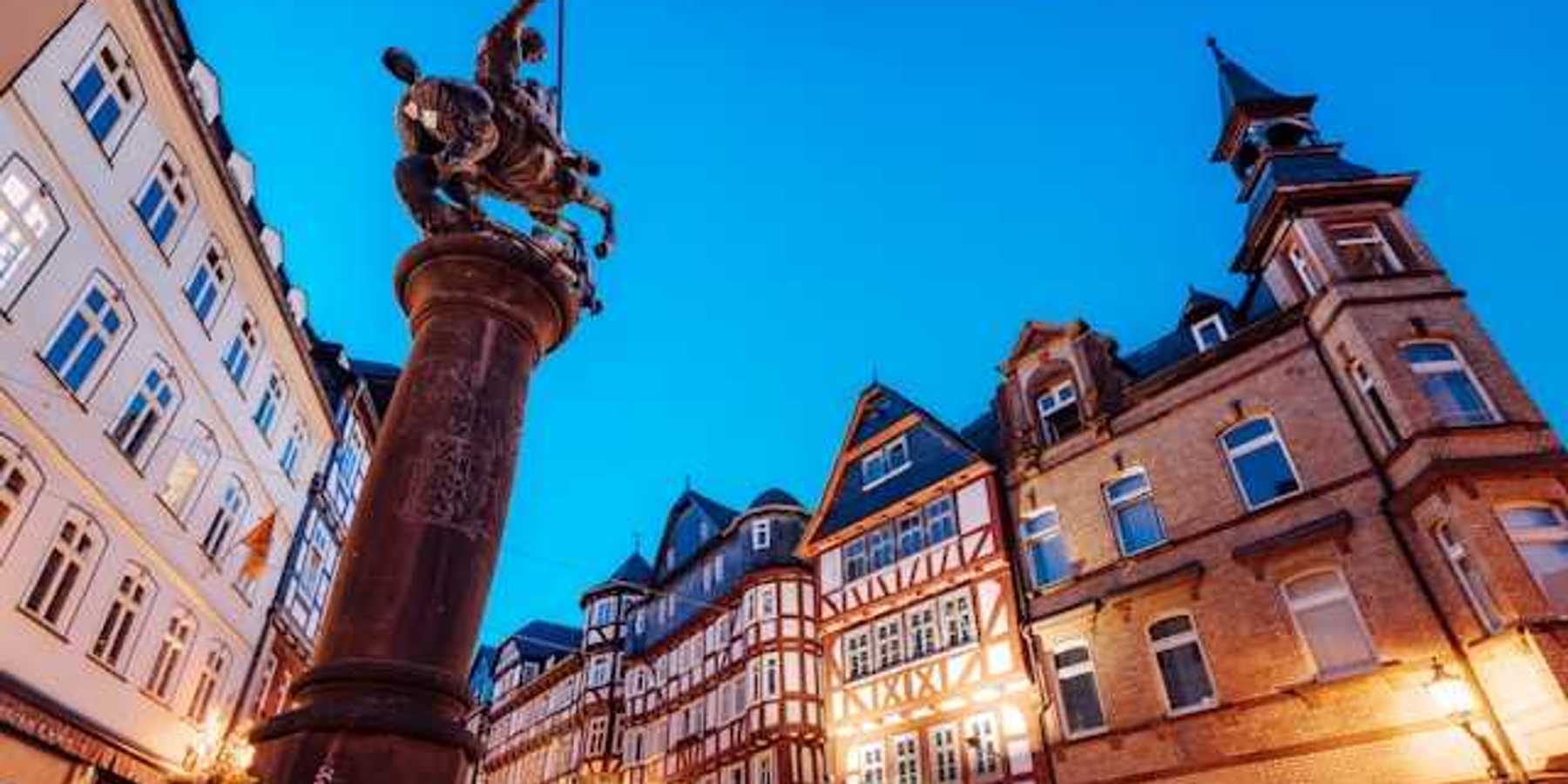 A view of a European square with half-timbered houses and a status of a man on a horse