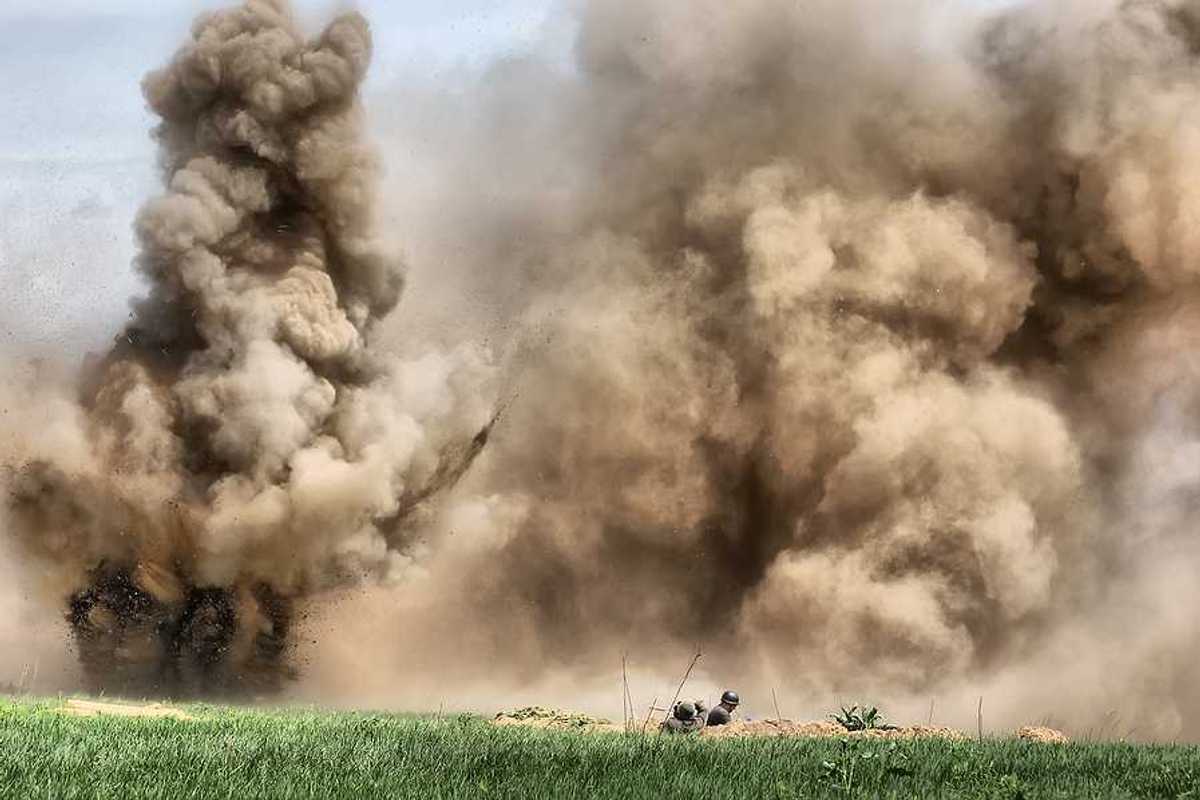 A view of a field under attack with bombs exploding