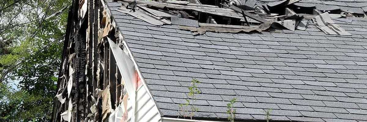 A view of a house roof that is partially burned