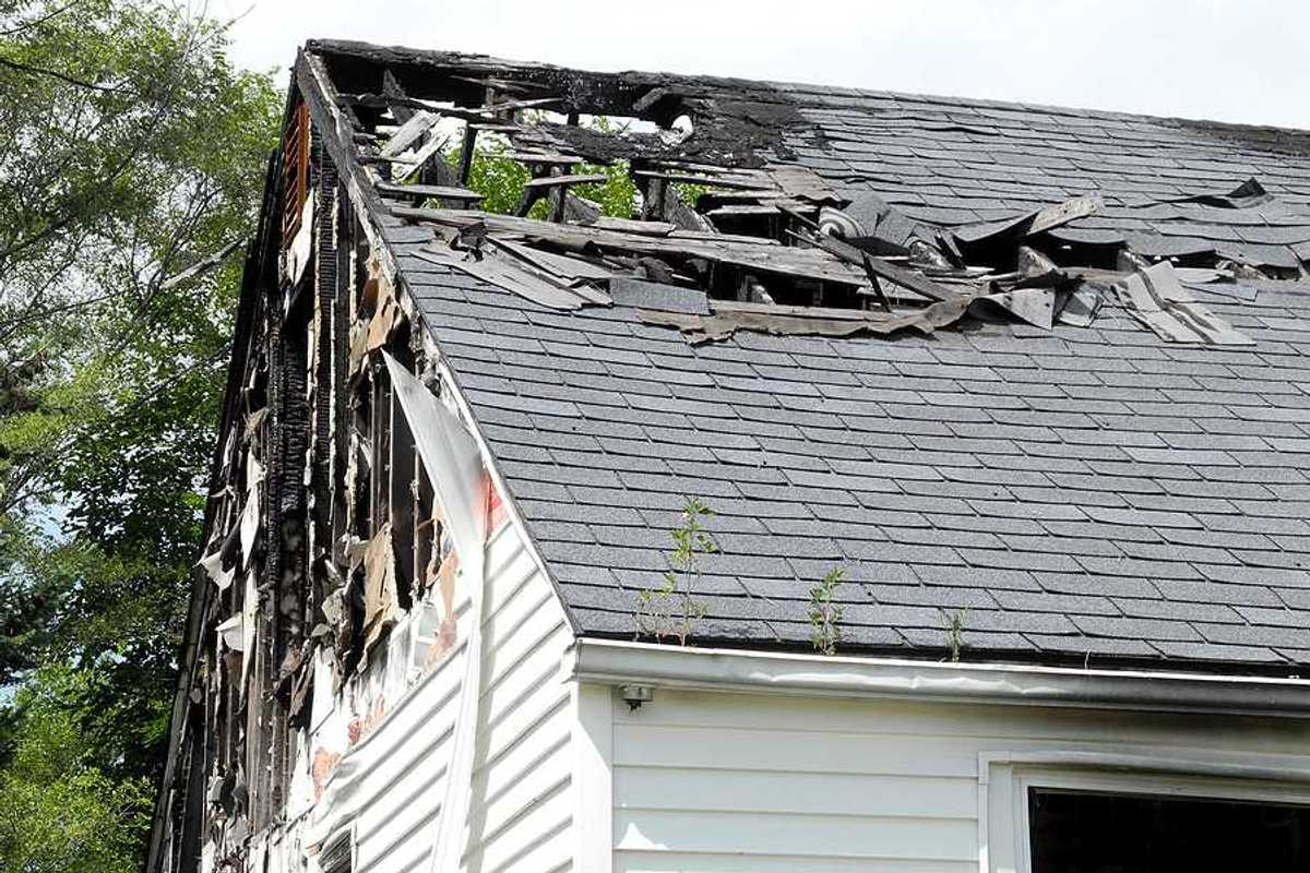 A view of a house roof that is partially burned