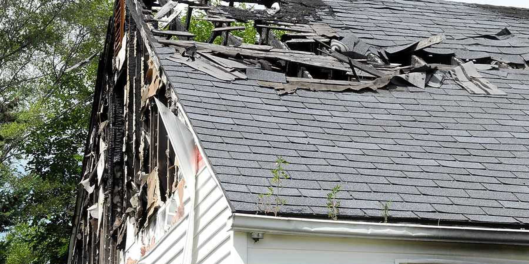 A view of a house roof that is partially burned
