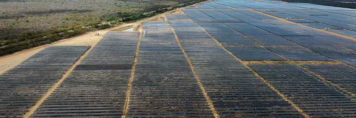 A view of a huge solar farm in Brazil with mountain ranges in the background