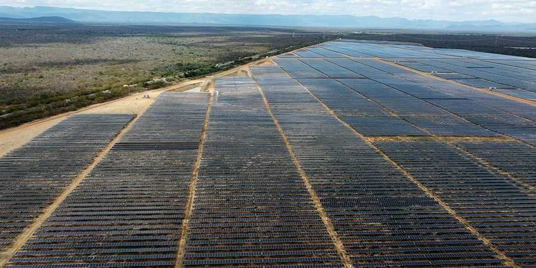 A view of a huge solar farm in Brazil with mountain ranges in the background