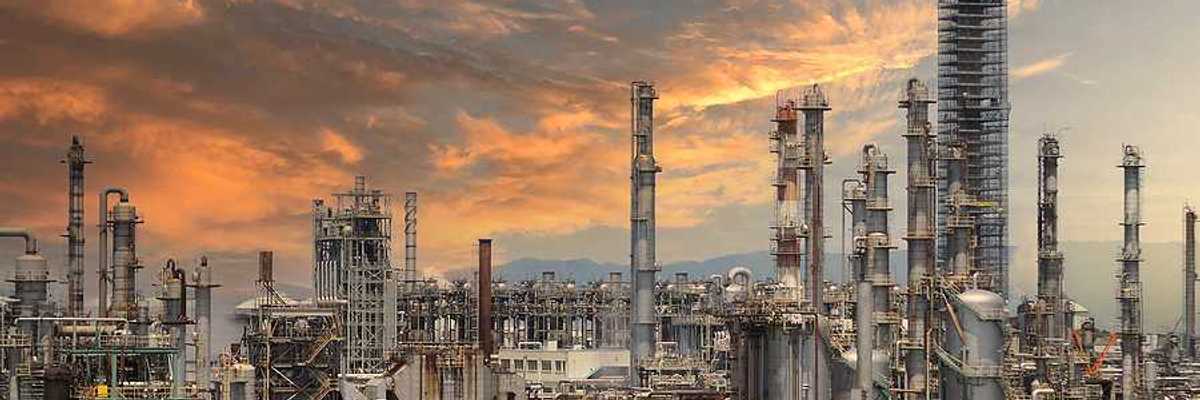 A view of a large petrochemical plant with the sunset in the background