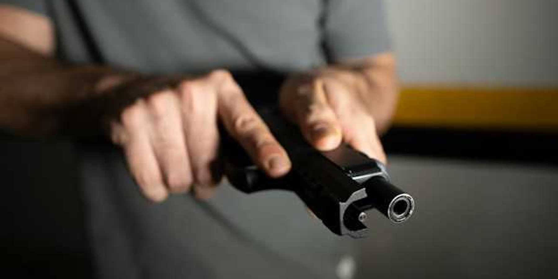 A view of a man's hand holding a black gun