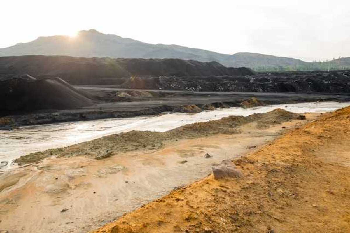 A view of a mining pit with a river in the foreground