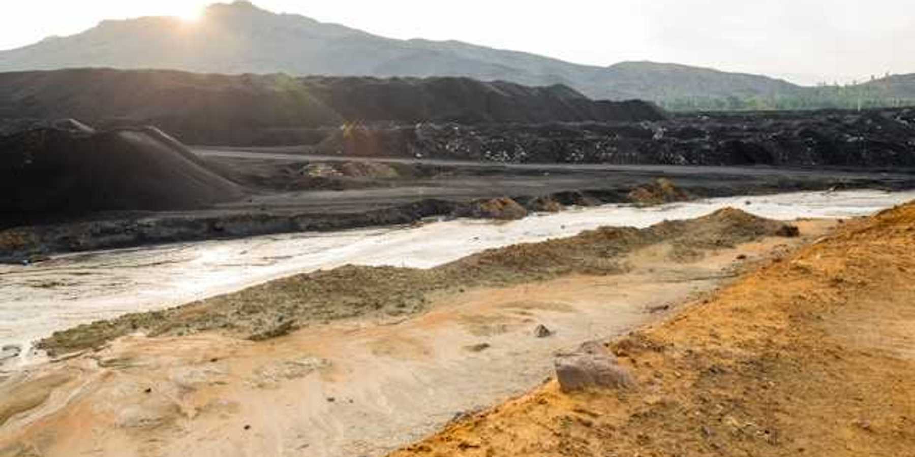 A view of a mining pit with a river in the foreground