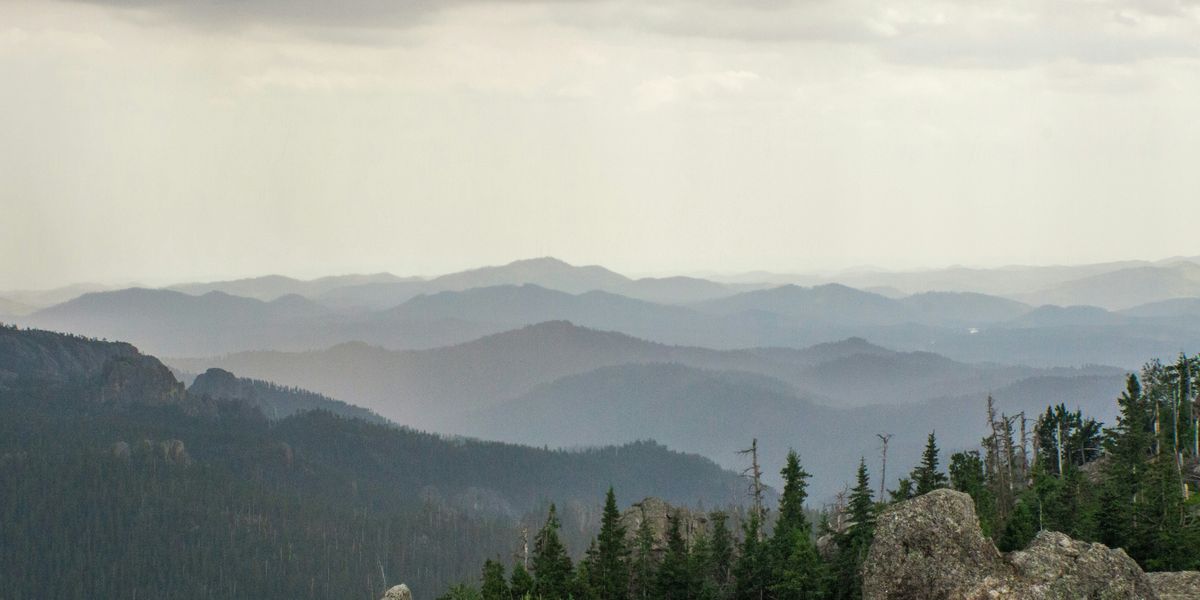 a view of a mountain range with trees and mountains in the background.